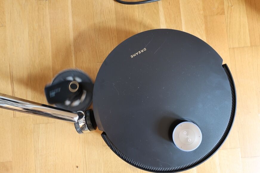 Dreame X60 Pro Ultra reinigt an Tischbeinen in einem möblierten Wohnzimmer